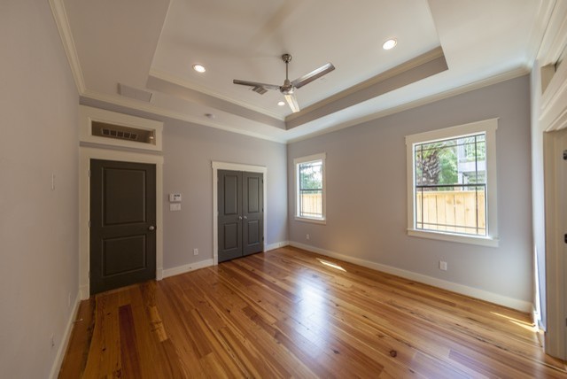 This is an example of a mid-sized arts and crafts master bedroom in Houston with white walls and light hardwood floors.
