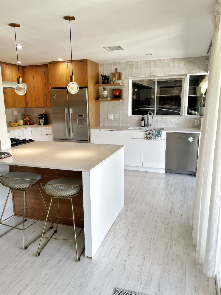 Design ideas for a small contemporary u-shaped separate kitchen in Phoenix with an undermount sink, flat-panel cabinets, medium wood cabinets, quartz benchtops, grey splashback, ceramic splashback, stainless steel appliances, light hardwood floors, no island, white floor and white benchtop.