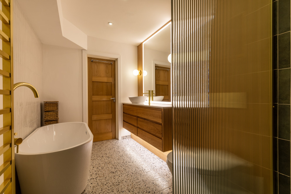 Exempel på ett stort modernt vit vitt en-suite badrum, med skåp i ljust trä, ett fristående badkar, en öppen dusch, en vägghängd toalettstol, grön kakel, porslinskakel, vita väggar, klinkergolv i porslin, ett konsol handfat, marmorbänkskiva, vitt golv och med dusch som är öppen
