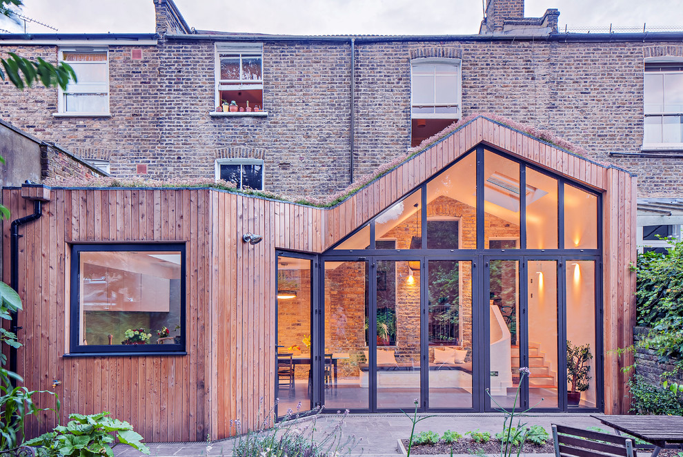 Photo of a small contemporary one-storey exterior in London with wood siding.