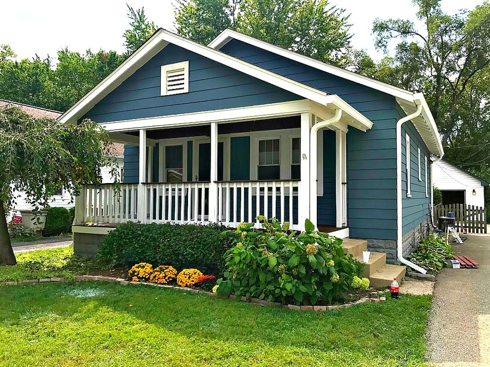 This is an example of a mid-sized arts and crafts one-storey blue house exterior in Indianapolis with wood siding, a gable roof and a shingle roof.