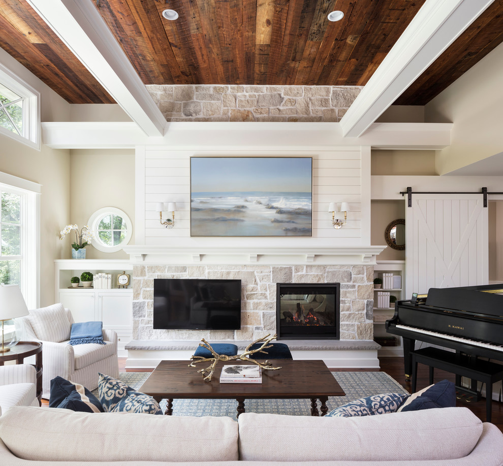 This is an example of a beach style family room in Minneapolis with white walls, dark hardwood floors, a standard fireplace, a stone fireplace surround and a wall-mounted tv.