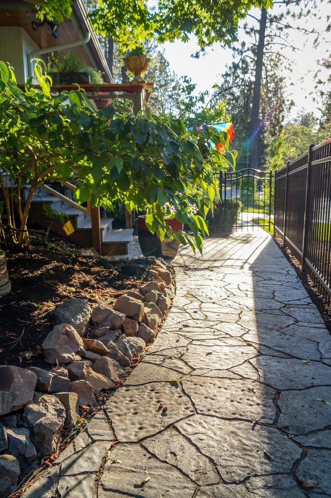 This is an example of a mid-sized rustic partial sun backyard concrete paver retaining wall landscape.