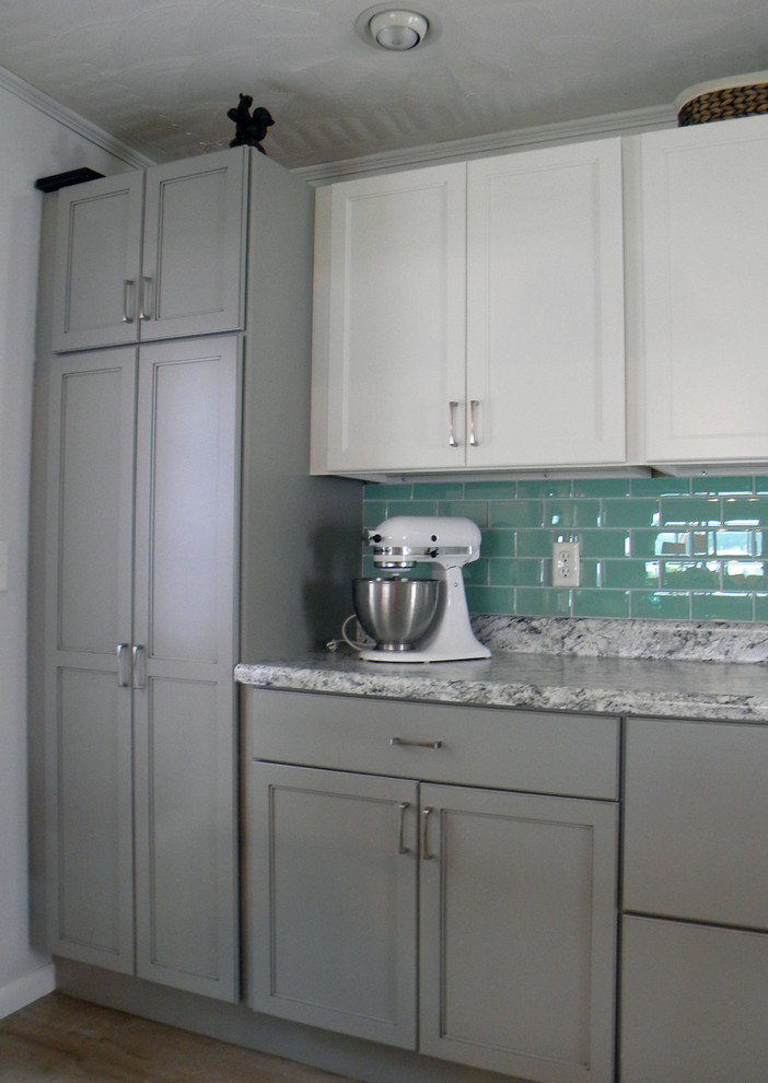 Example of a large transitional single-wall kitchen pantry design with a drop-in sink, recessed-panel cabinets, white cabinets, stainless steel appliances and no island