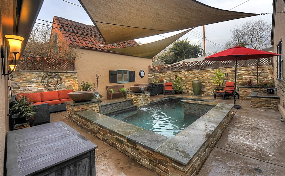Photo of a small transitional backyard rectangular natural pool in Orange County with a water feature and stamped concrete.