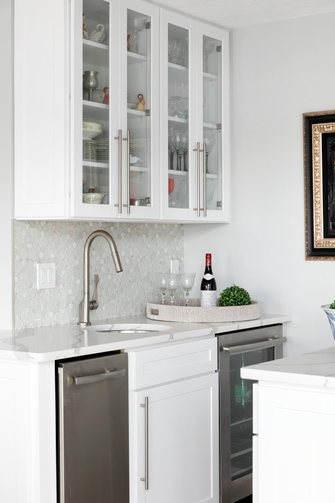 Inspiration for a transitional single-wall wet bar in Tampa with an undermount sink, shaker cabinets, white cabinets, white splashback, mosaic tile splashback and white benchtop.