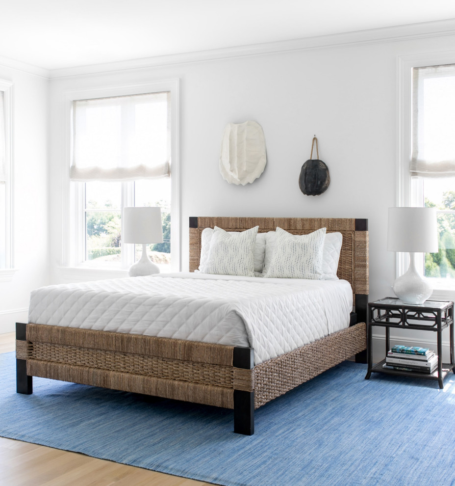 Photo of a beach style bedroom in New York with white walls, light hardwood flooring and beige floors.