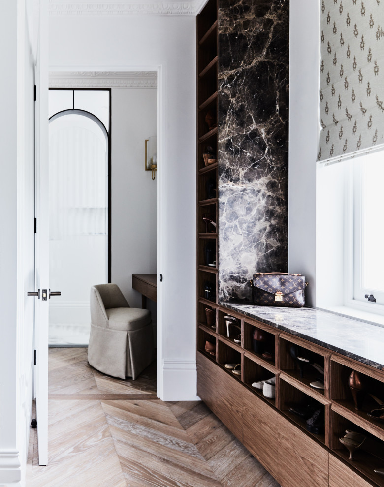 This is an example of a transitional gender-neutral dressing room in Sydney with open cabinets, medium wood cabinets, medium hardwood floors and brown floor.