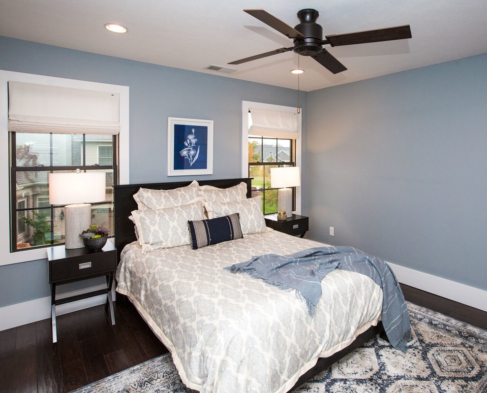 This is an example of a contemporary bedroom in Indianapolis with blue walls, dark hardwood floors and brown floor.