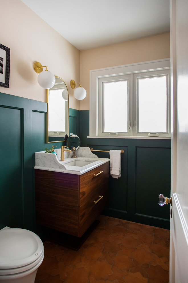 Idéer för mellanstora vintage vitt badrum med dusch, med släta luckor, skåp i mörkt trä, en dusch i en alkov, en vägghängd toalettstol, grön kakel, keramikplattor, gröna väggar, klinkergolv i keramik, ett nedsänkt handfat, marmorbänkskiva, rött golv och dusch med gångjärnsdörr
