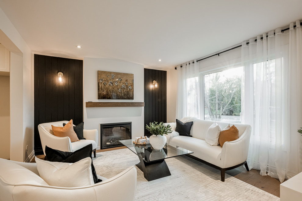 This is an example of a mid-sized modern formal enclosed living room in Montreal with light hardwood floors, a standard fireplace, planked wall panelling and beige floor.