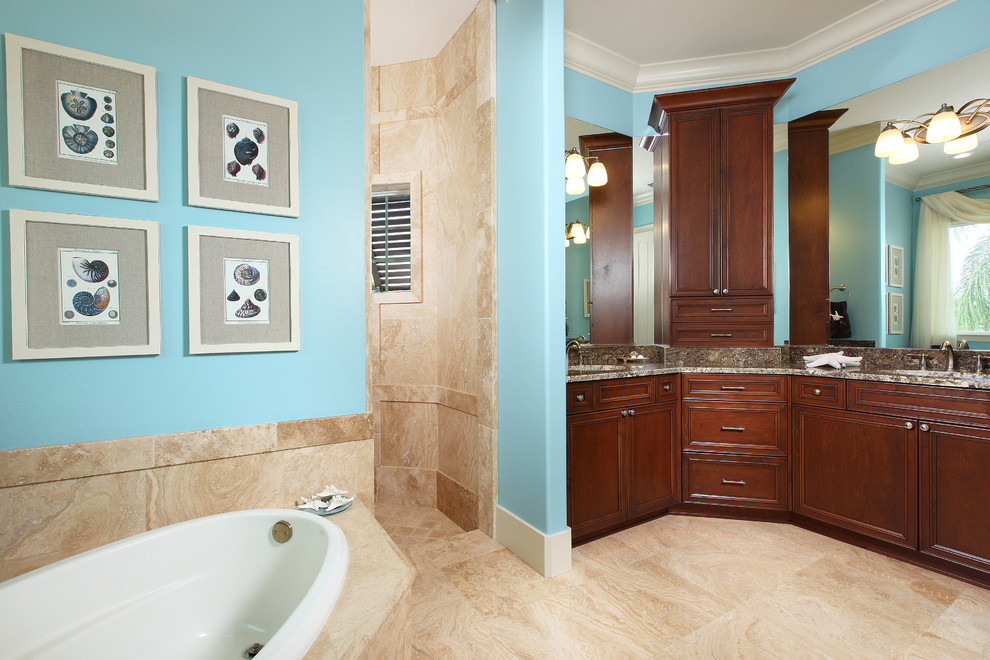 Inspiration for a large beach style master bathroom in Miami with an undermount sink, shaker cabinets, dark wood cabinets, granite benchtops, a drop-in tub, an open shower, a one-piece toilet, beige tile and blue walls.