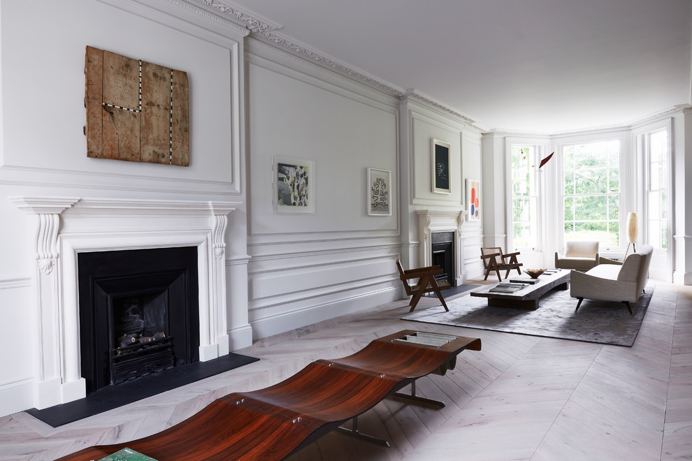 Inspiration for an expansive contemporary open concept living room in London with white walls and light hardwood floors.