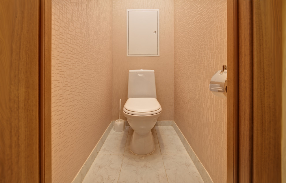 Modelo de aseo contemporáneo pequeño con paredes beige, suelo beige, papel pintado, sanitario de pared y suelo de mármol