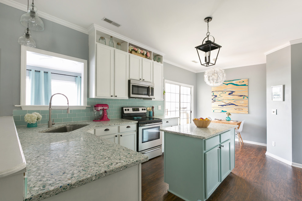 Inspiration for a mid-sized beach style u-shaped eat-in kitchen in Charleston with shaker cabinets, recycled glass benchtops, blue splashback, stainless steel appliances, with island, a single-bowl sink, blue cabinets, dark hardwood floors, brown floor and subway tile splashback.
