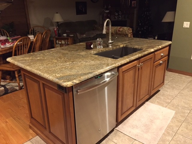 Example of a mid-sized classic ceramic tile kitchen design with an undermount sink, recessed-panel cabinets, medium tone wood cabinets, granite countertops, stainless steel appliances and an island