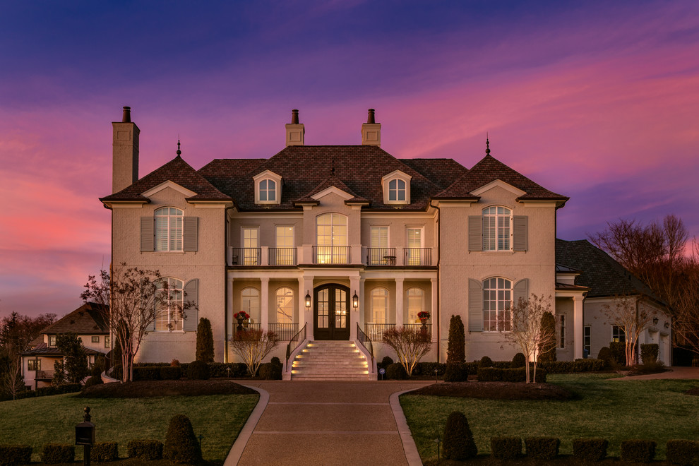 Traditional two-storey brick white house exterior in Nashville with a hip roof and a shingle roof.