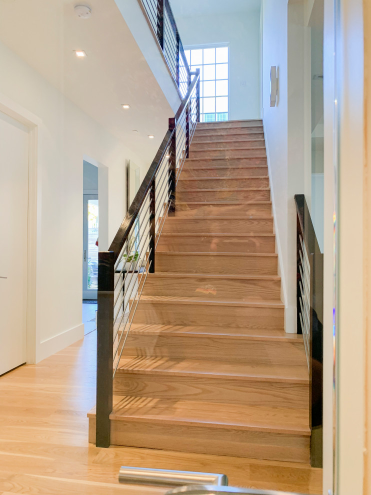 Photo of a large contemporary wood spiral staircase in DC Metro with wood risers and mixed railing.