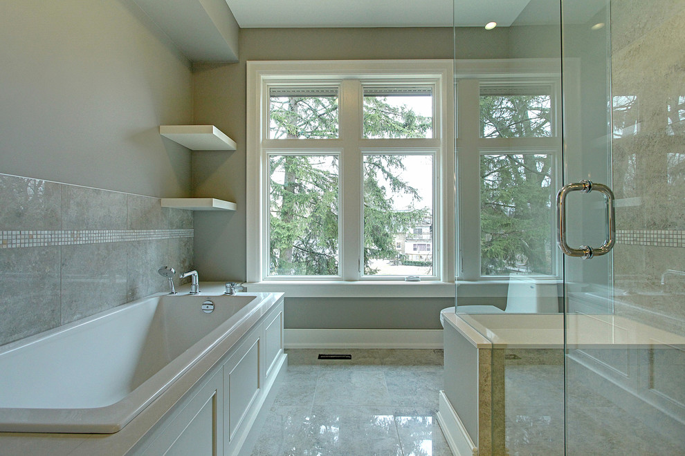 This is an example of a mid-sized transitional 3/4 bathroom in Toronto with a freestanding tub, grey walls, an undermount sink, shaker cabinets, white cabinets, a corner shower, a one-piece toilet and marble floors.