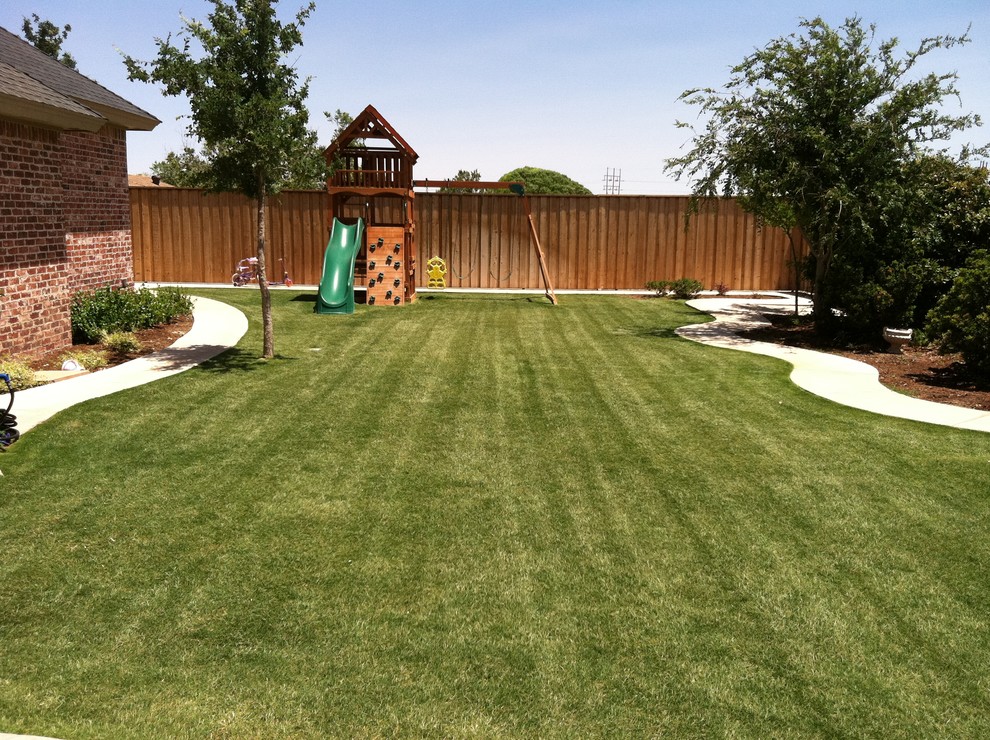 Mid-sized traditional backyard full sun garden in Austin with with outdoor playset and concrete pavers for summer.