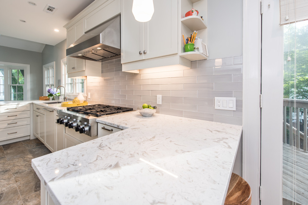 This is an example of a mid-sized contemporary galley eat-in kitchen in DC Metro with an undermount sink, recessed-panel cabinets, white cabinets, quartz benchtops, grey splashback, subway tile splashback, stainless steel appliances, slate floors, a peninsula, multi-coloured floor and white benchtop.