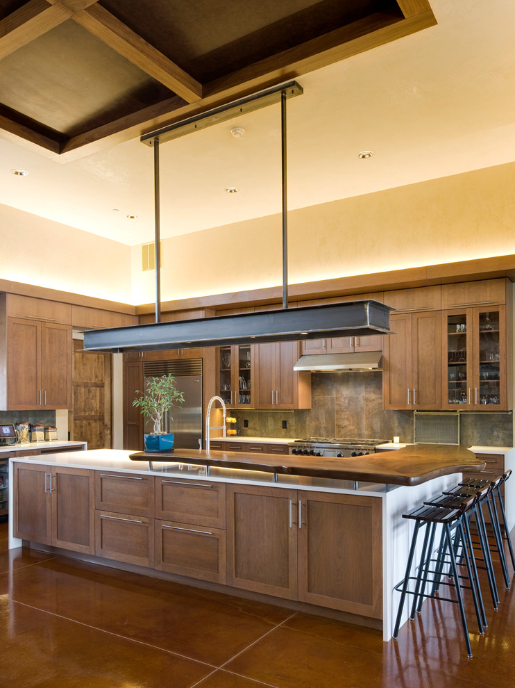 Photo of an expansive country l-shaped eat-in kitchen in Albuquerque with shaker cabinets, dark wood cabinets, wood benchtops, multi-coloured splashback, stainless steel appliances, an undermount sink, stone tile splashback, concrete floors and with island.