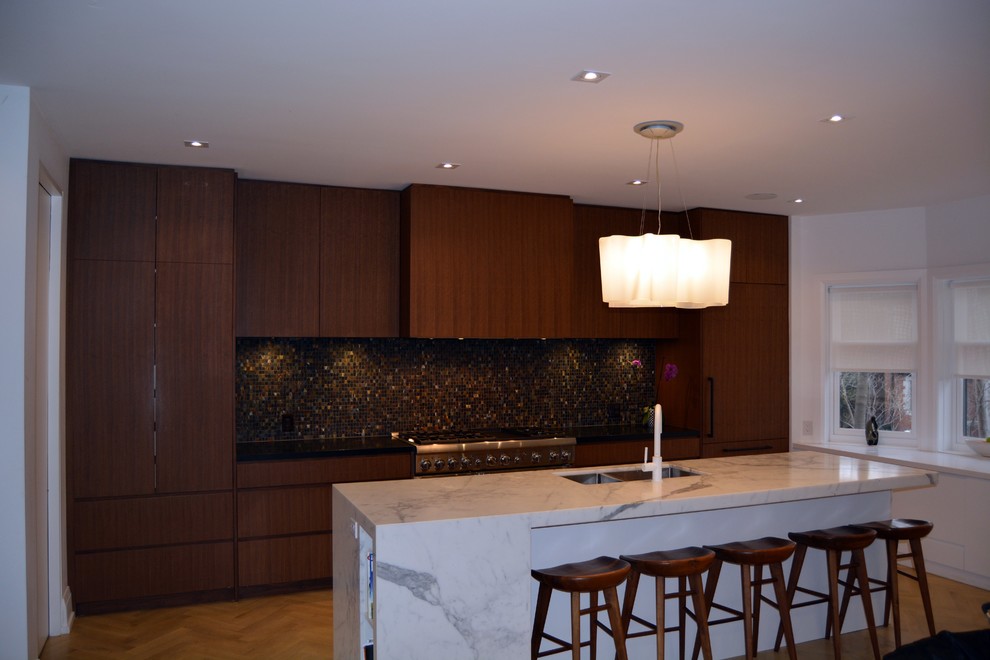 Inspiration for a large transitional single-wall separate kitchen in Toronto with an undermount sink, flat-panel cabinets, brown cabinets, marble benchtops, brown splashback, mosaic tile splashback, stainless steel appliances, light hardwood floors and with island.