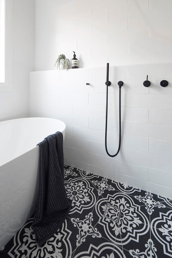 This is an example of a small traditional 3/4 wet room bathroom in Melbourne with black cabinets, a freestanding tub, a wall-mount toilet, white tile, subway tile, white walls, an undermount sink, laminate benchtops, multi-coloured floor, an open shower, white benchtops, furniture-like cabinets and porcelain floors.