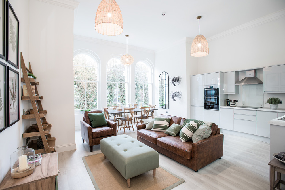 This is an example of a scandi open plan living room in Essex with white walls and white floors.