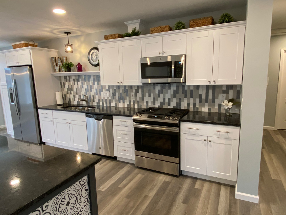 Inspiration for a large transitional l-shaped vinyl floor and gray floor open concept kitchen remodel in Cincinnati with an undermount sink, raised-panel cabinets, white cabinets, granite countertops, multicolored backsplash, ceramic backsplash, stainless steel appliances, an island and black countertops