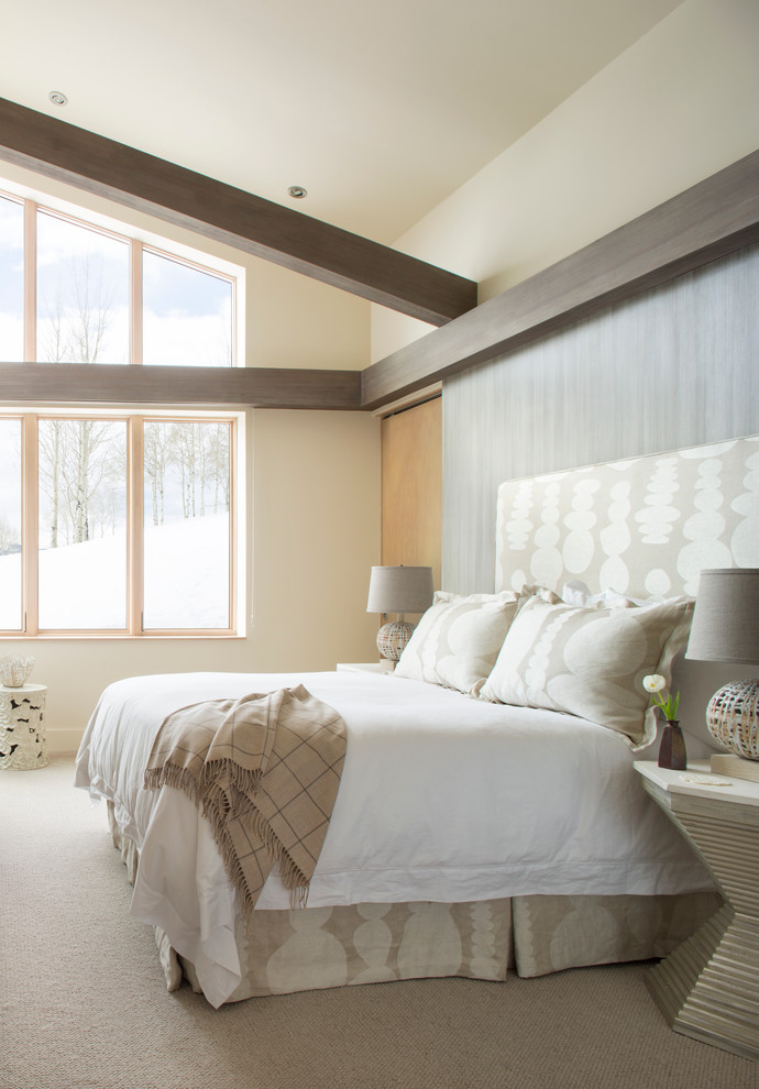 This is an example of a contemporary master bedroom in Denver with beige walls and carpet.