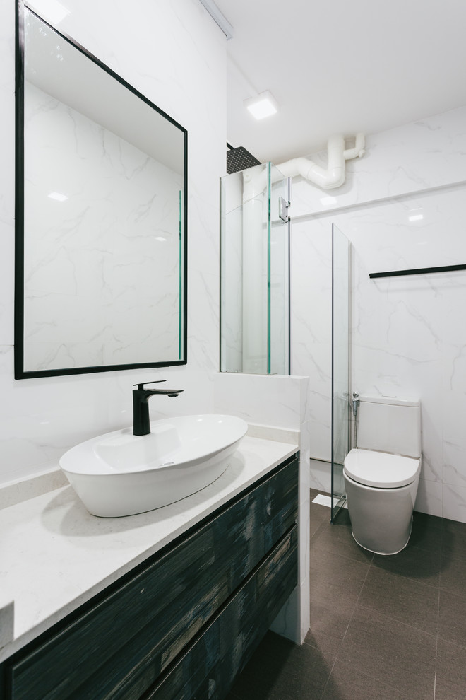 This is an example of an asian 3/4 bathroom in Singapore with flat-panel cabinets, distressed cabinets, an alcove shower, a one-piece toilet, white tile, white walls, a vessel sink, grey floor, a hinged shower door and grey benchtops.