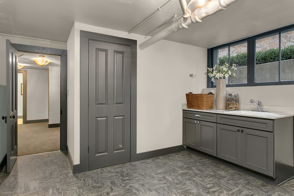 Large traditional single-wall dedicated laundry room in Seattle with raised-panel cabinets, grey cabinets, quartzite benchtops, grey walls and a drop-in sink.