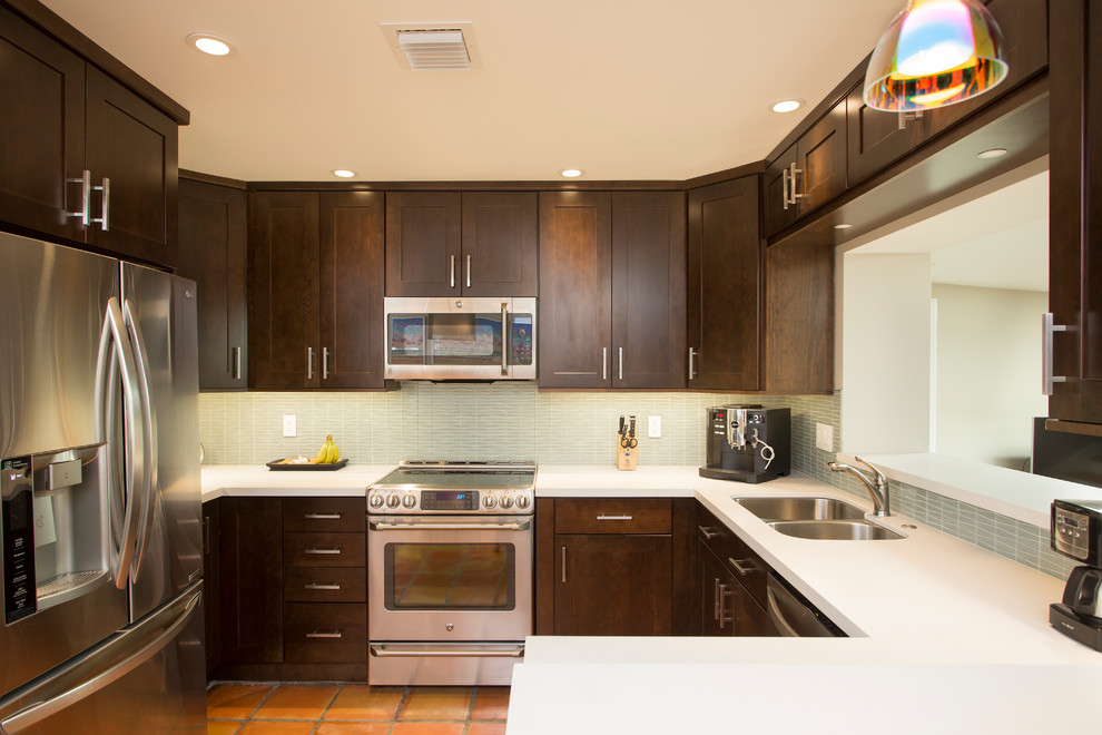 Inspiration for a small transitional u-shaped terra-cotta tile eat-in kitchen remodel in Miami with an undermount sink, shaker cabinets, dark wood cabinets, quartz countertops, green backsplash, glass tile backsplash and stainless steel appliances