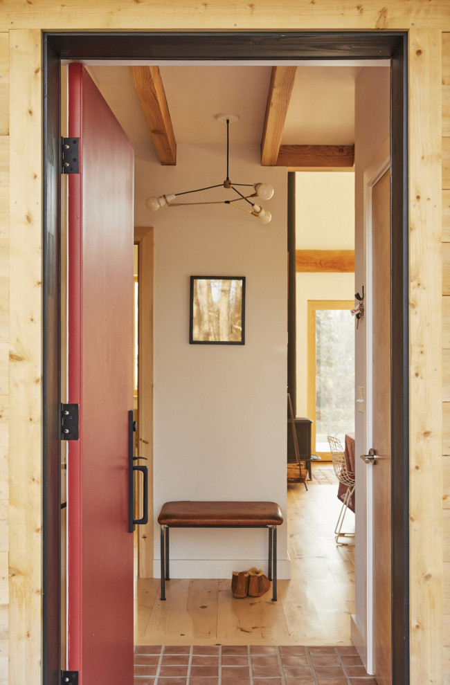 This is an example of a mid-sized contemporary foyer in Portland Maine with white walls, terra-cotta floors, a single front door, a red front door and exposed beam.