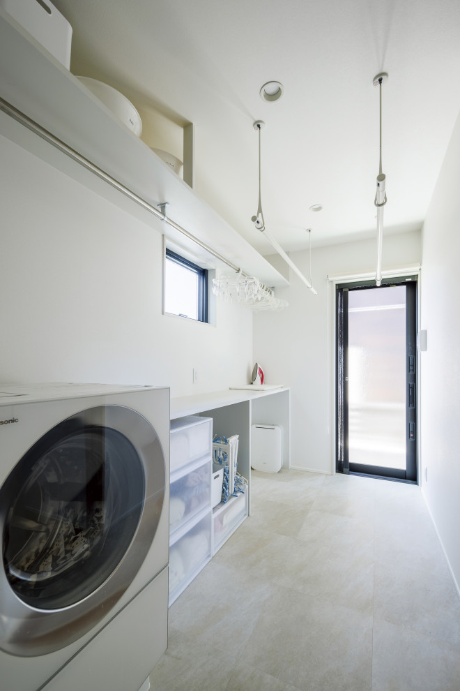 Foto di una lavanderia minimalista con pareti bianche, pavimento in legno verniciato, lavasciuga, pavimento grigio, top bianco, soffitto in carta da parati e carta da parati