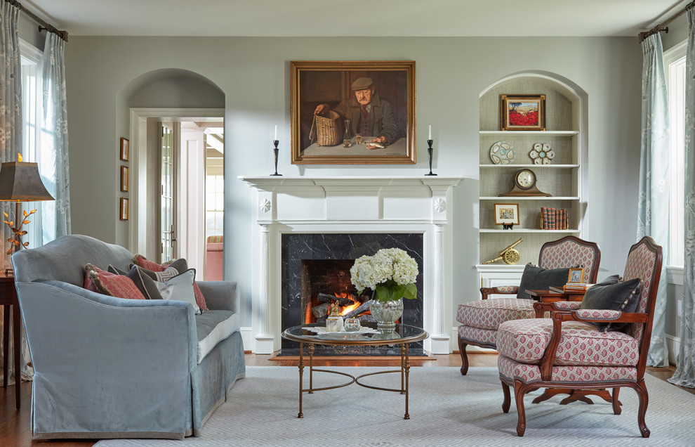 This is an example of a traditional formal enclosed living room in Baltimore with grey walls, medium hardwood floors, a standard fireplace, a stone fireplace surround and no tv.