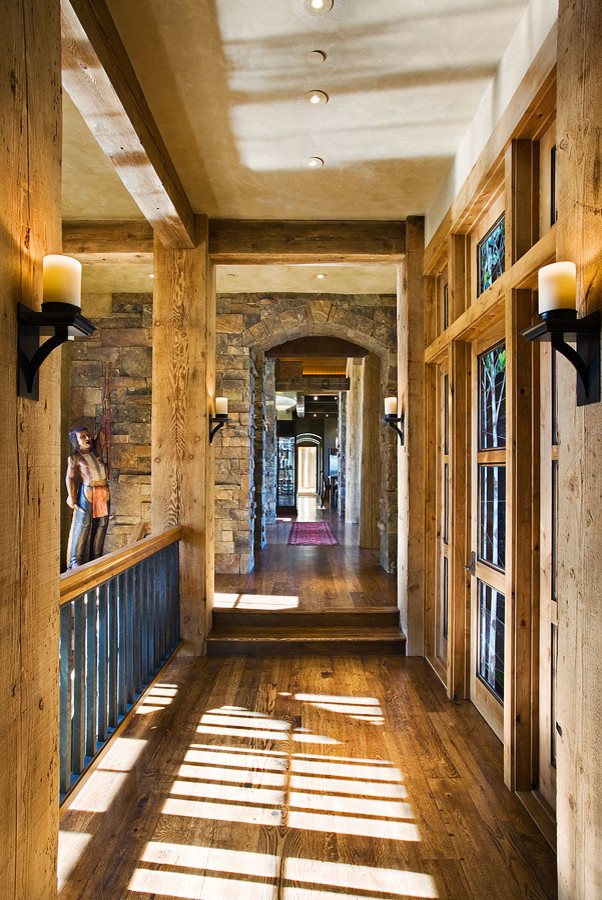 Large country hallway in Other with multi-coloured walls, dark hardwood floors and brown floor.