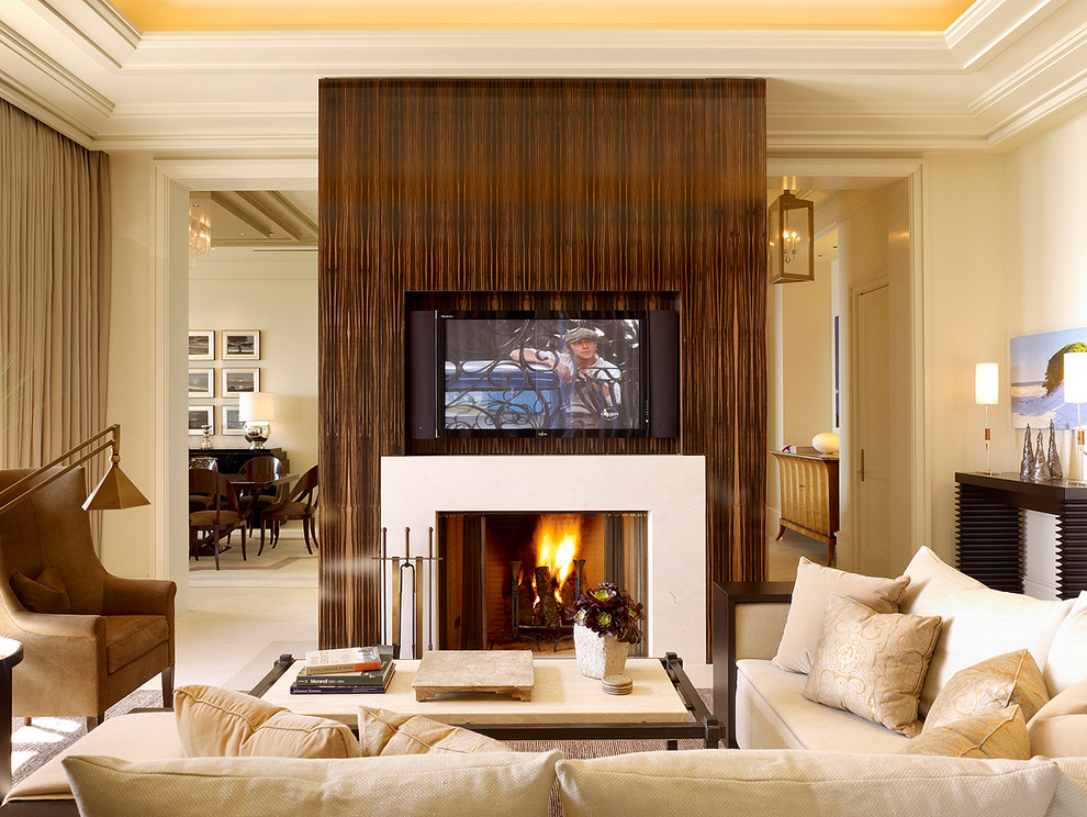 This is an example of a contemporary living room in San Francisco with beige walls, a standard fireplace and a built-in media wall.