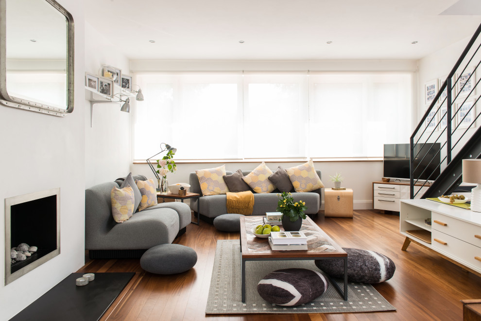 Photo of a medium sized contemporary open plan living room in London with white walls, brown floors and medium hardwood flooring.