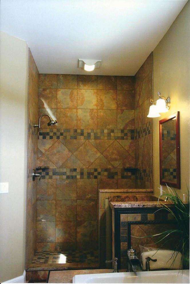 Photo of a large traditional master bathroom in Other with an undermount sink, raised-panel cabinets, dark wood cabinets, granite benchtops, a drop-in tub, an open shower, a one-piece toilet, multi-coloured tile, ceramic tile, yellow walls and ceramic floors.