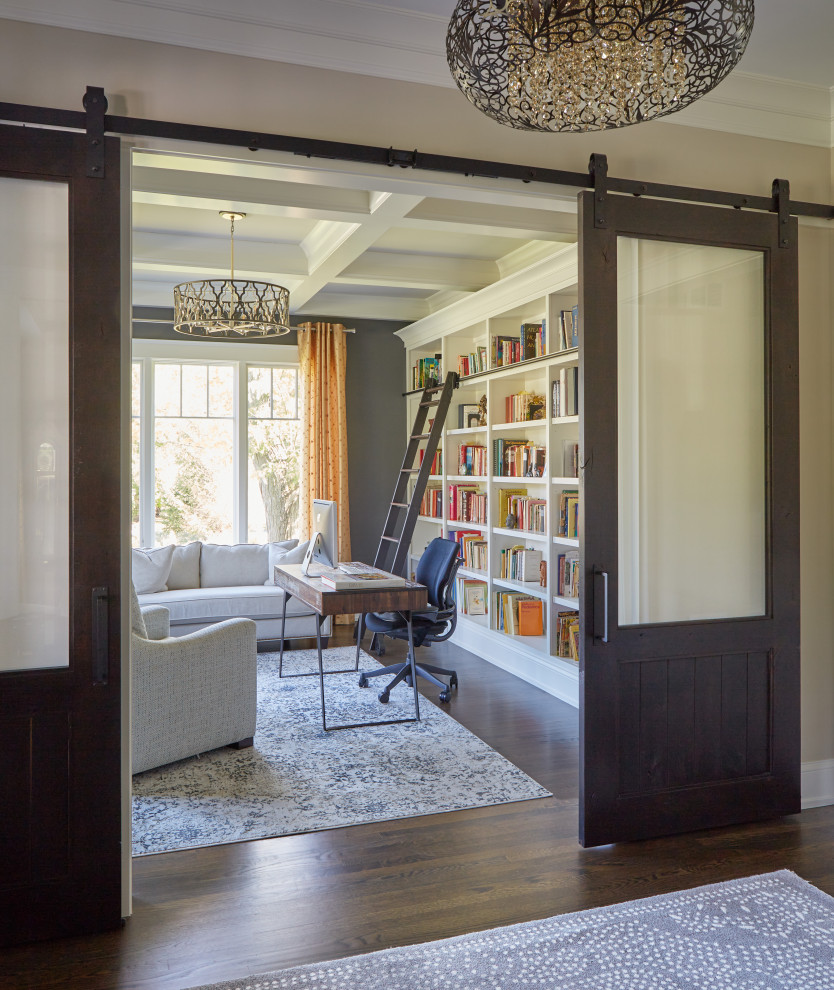 Inspiration för ett stort hemmabibliotek, med grå väggar, mellanmörkt trägolv, ett fristående skrivbord och brunt golv