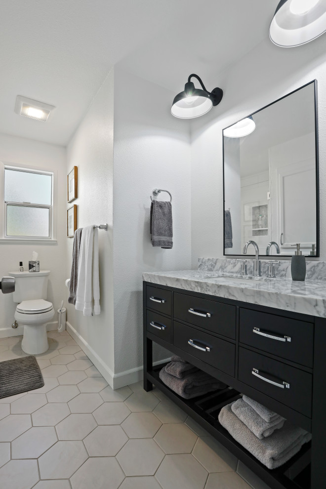 Пример оригинального дизайна: ванная комната в современном стиле с черными фасадами, угловым душем, белыми стенами, полом из керамической плитки, врезной раковиной, мраморной столешницей, душем с распашными дверями, серой столешницей и тумбой под одну раковину