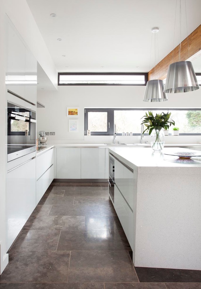 Design ideas for a large contemporary open plan kitchen in Other with an undermount sink, flat-panel cabinets, grey cabinets, quartzite benchtops, white splashback, glass sheet splashback, stainless steel appliances, ceramic floors and with island.