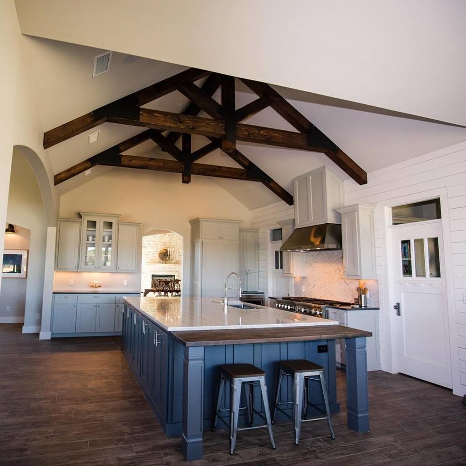 Mid-sized transitional l-shaped dark wood floor and brown floor open concept kitchen photo in Austin with an undermount sink, recessed-panel cabinets, gray cabinets, marble countertops, white backsplash, ceramic backsplash, stainless steel appliances and an island