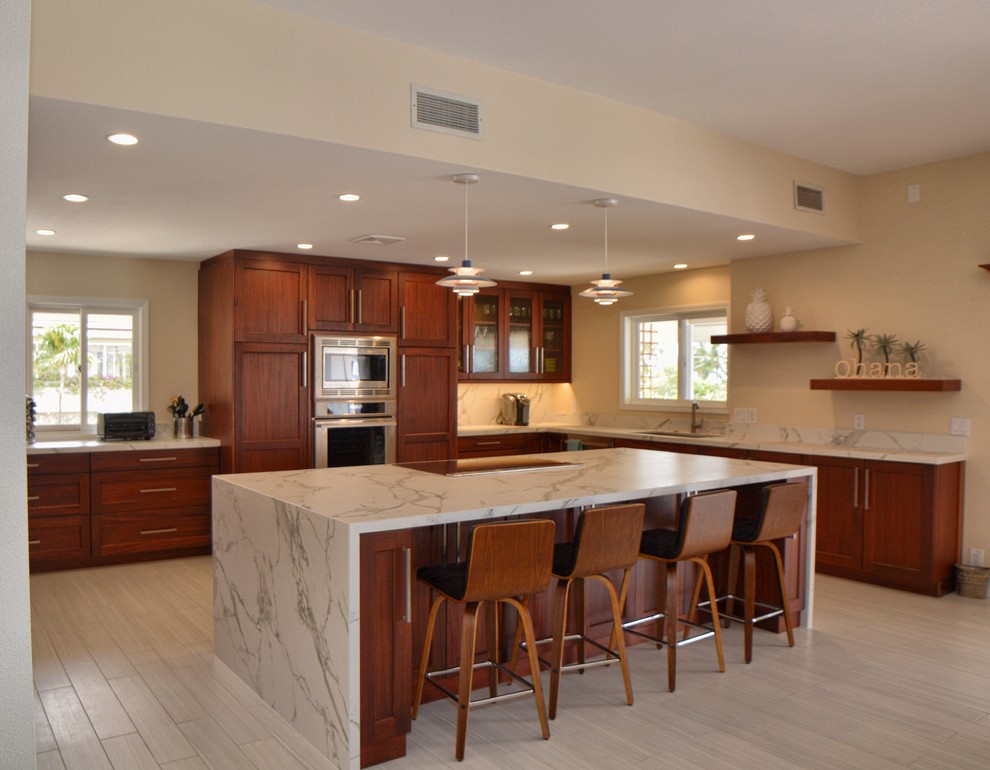 Large traditional kitchen in Hawaii with with island, a single-bowl sink, shaker cabinets, medium wood cabinets, quartz benchtops, grey splashback, stainless steel appliances, porcelain floors, grey floor and grey benchtop.