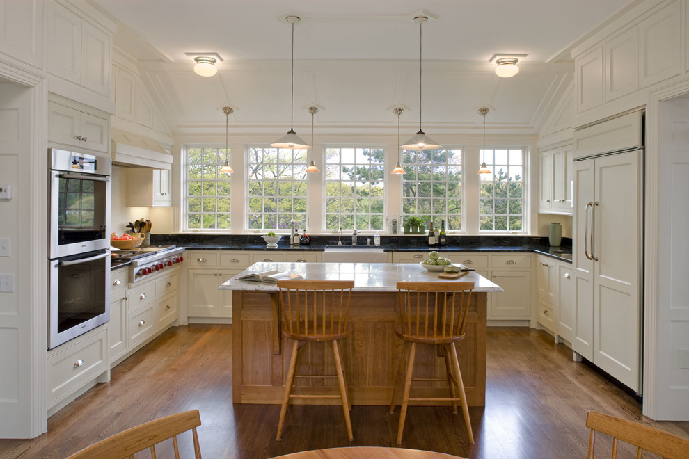 Traditional u-shaped kitchen in Boston with panelled appliances.