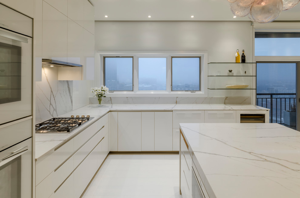 Photo of a large contemporary u-shaped eat-in kitchen in Other with an undermount sink, flat-panel cabinets, white cabinets, marble benchtops, white splashback, marble splashback, panelled appliances, light hardwood floors, with island and white floor.