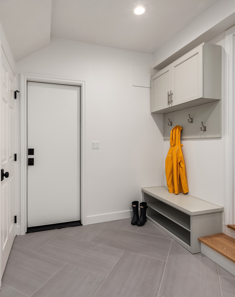 Design ideas for a transitional utility room in Seattle with flat-panel cabinets, grey cabinets, white walls, porcelain floors and grey floor.