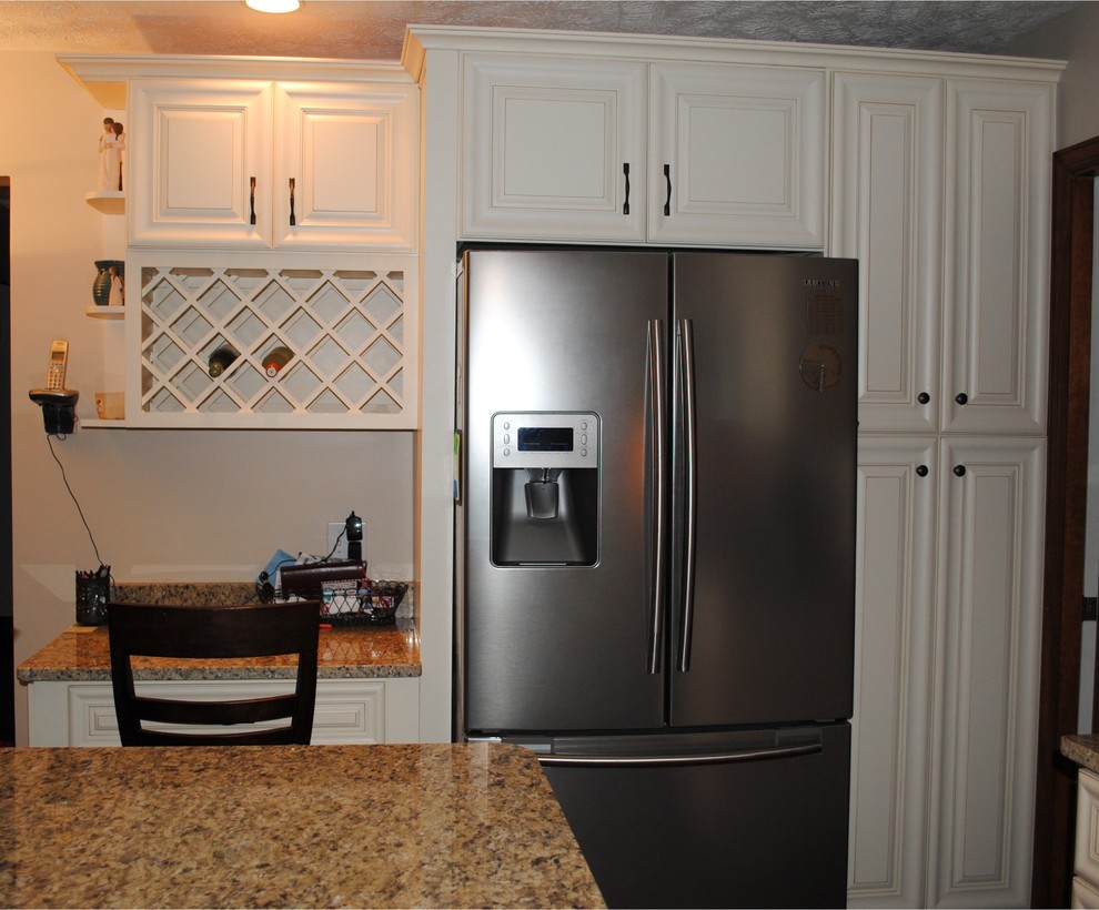 Example of a classic l-shaped eat-in kitchen design in Other with an undermount sink, raised-panel cabinets, white cabinets, granite countertops and stainless steel appliances